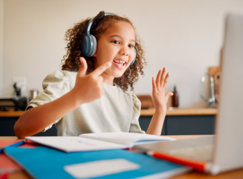Girl wearing headphones counts with her fingers to demonstrate newfound math skills during her tutoring session.
