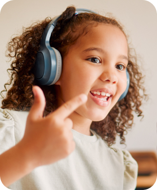 Girl wearing headphones counts with her fingers to demonstrate newfound math skills during her tutoring session.