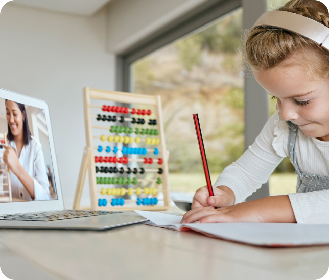 Young female student works independently during at her tablet with abacus.